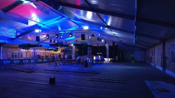 Event-Location bei Nacht mit blauer und violetter Bühnenbeleuchtung – Aufbau einer Veranstaltung durch TIMELESS Eventpersonal