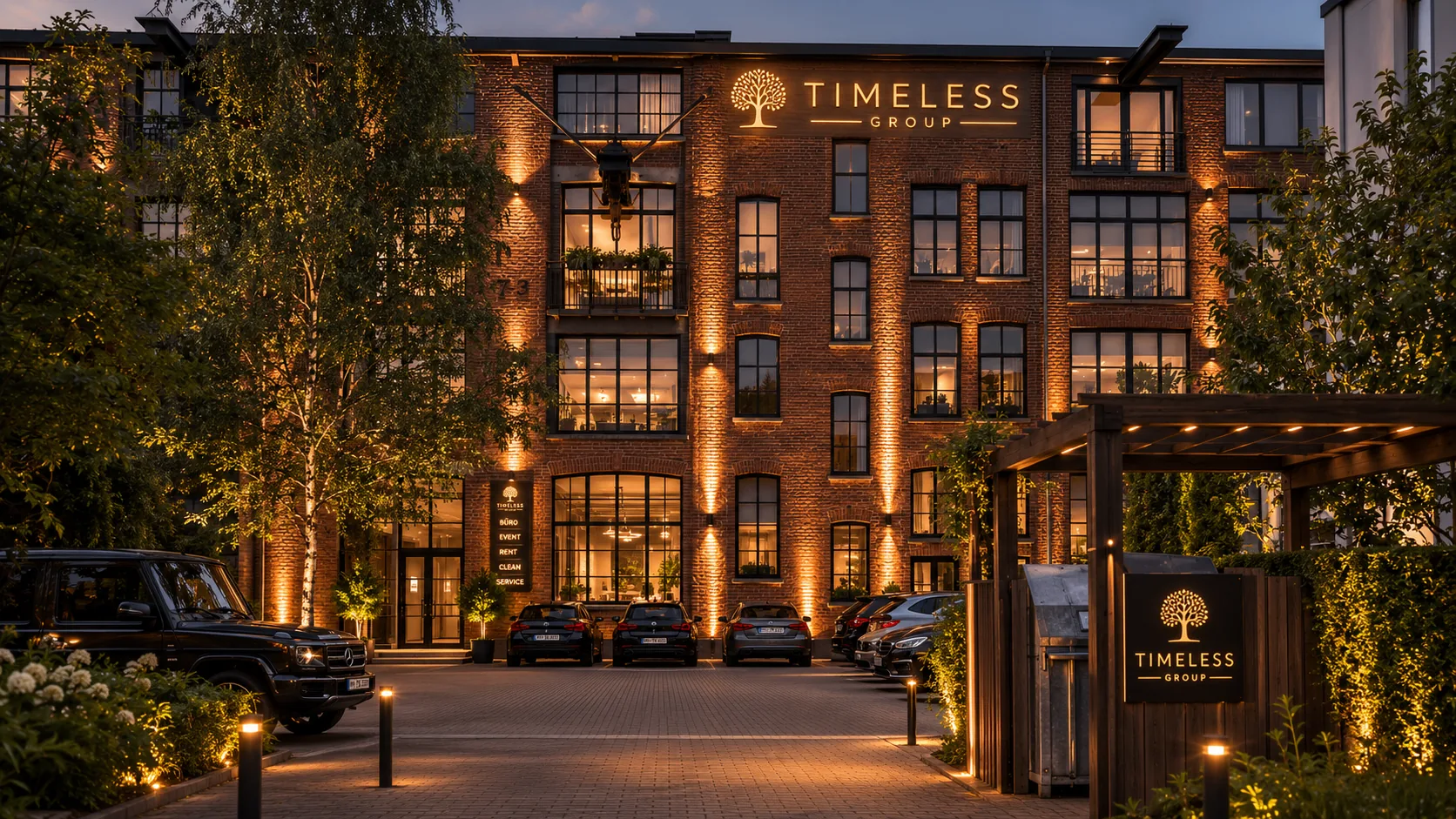 TIMELESS GROUP Firmengebäude in Hamburg bei Dämmerung mit beleuchtetem Logo an der Backsteinfassade