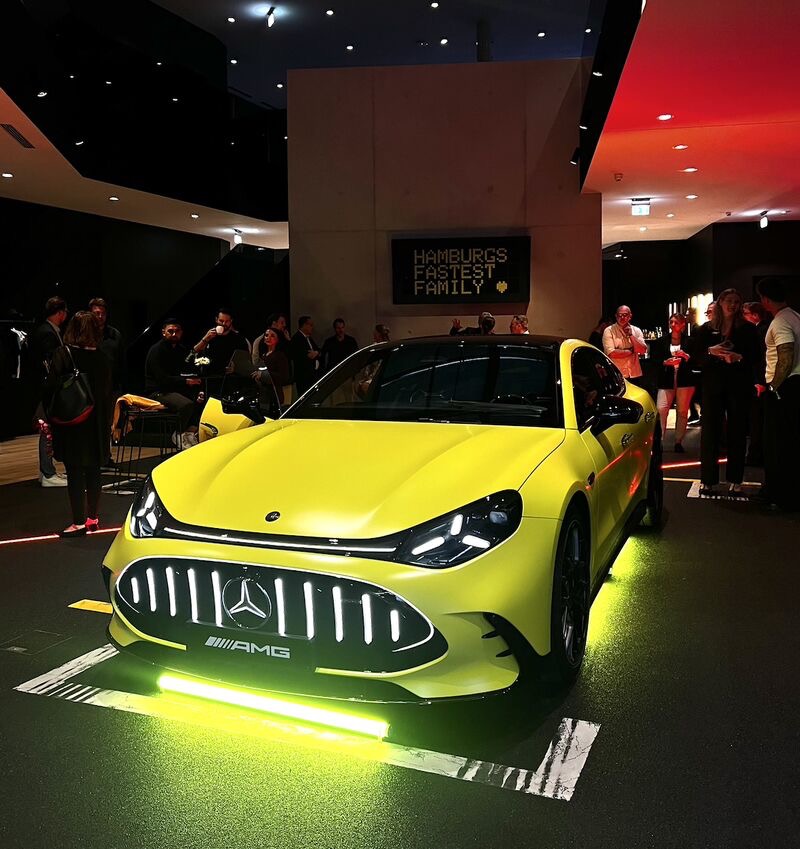 Mercedes-AMG Event in Hamburg – gelber AMG mit LED-Schriftzug „Hamburgs Fastest Family“, Gäste im Hintergrund