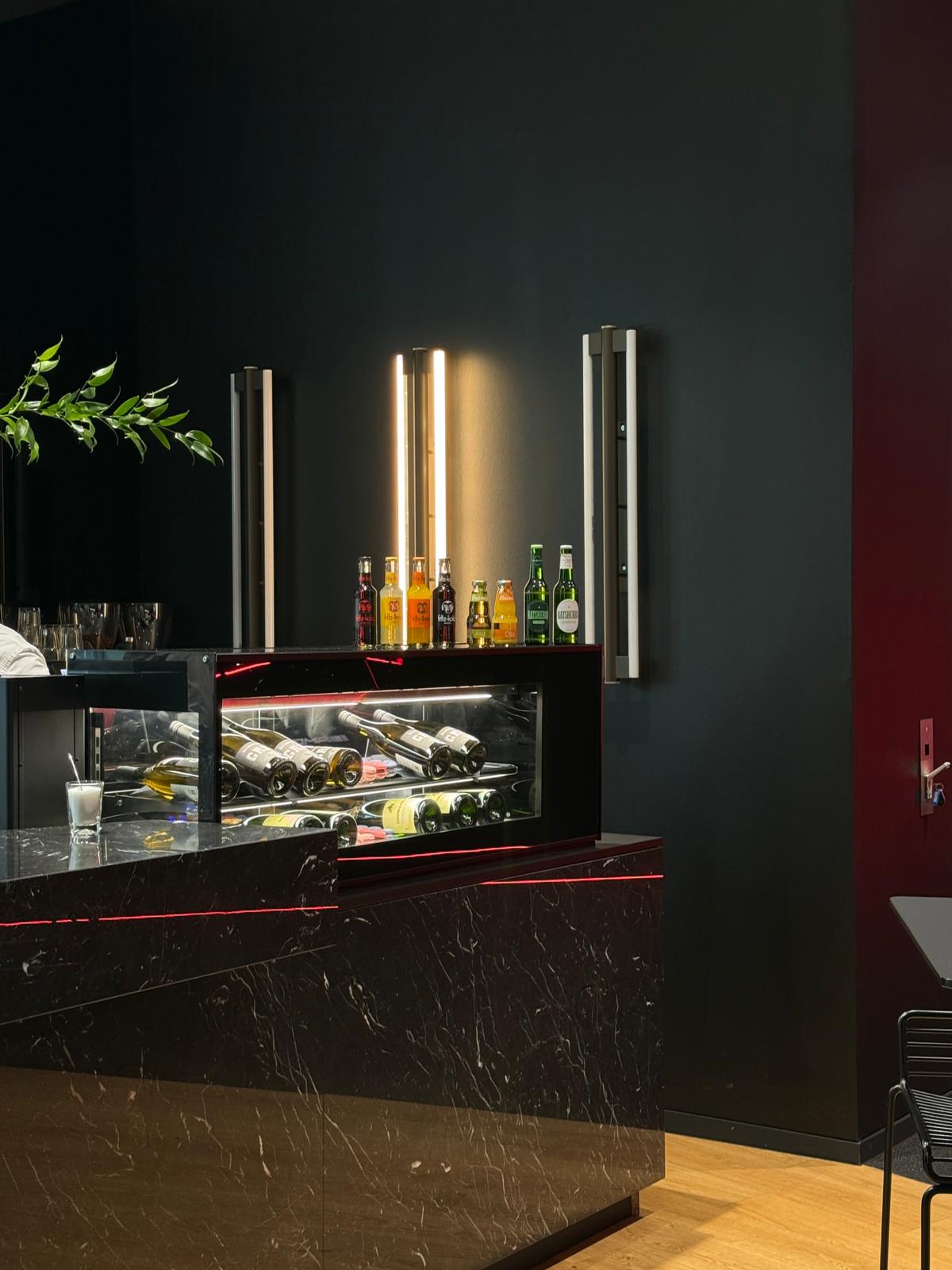 TIMELESS Bar-Setup bei einem Event – schwarze Marmorbar mit beleuchteter Weinvitrine und Getränke-Auswahl